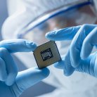 Engineer in sterile cleanroom holding microchip