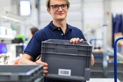 warehouse worker with barcoded plastic bin